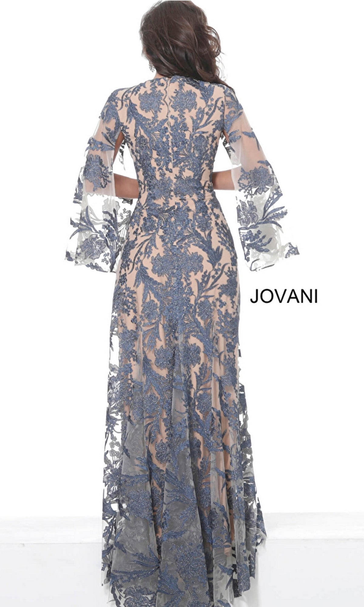 A woman faces away in the Embroidered Long Formal Gown 00752 with long sheer bell sleeves and blue floral lace over a nude underlayer. The word